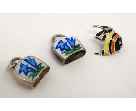 3 charms / pendants, two white metal examples formed as bells with enamel decoration and a silver example formed as a tropica