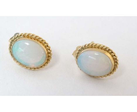 A pair of 9ct gold stud earrings set with opal cabochon with rope twist mounts. CONDITION: Please Note -  we do not make refe