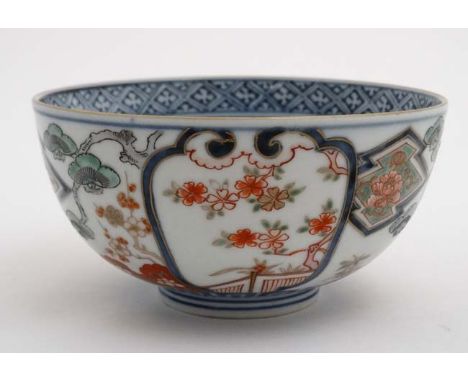 A Japanese ceramic bowl having floral decoration including flowering cherry blossom boughs in Imari colours with gilt highlig