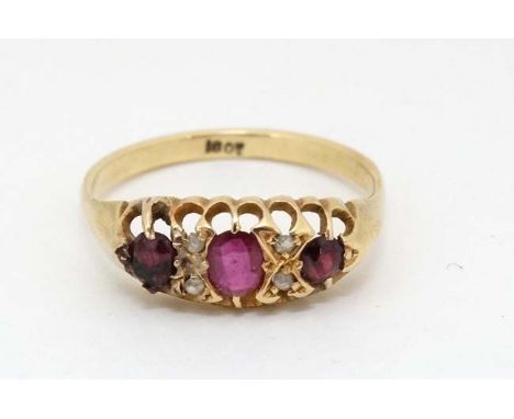 An 18ct gold ring set with central ruby flanked by 2 garnets and white stones  CONDITION: Please Note -  we do not make refer
