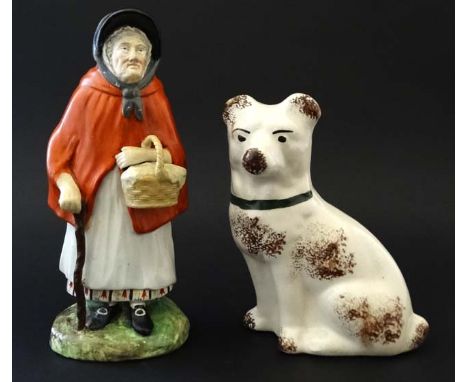A Victorian Staffordshire figure depicting an elderly female wearing red cloak, tied bonnet and holding a cane, and standing 