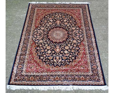Carpet / Rug : A machine made Keshan carpet, the blue and red ground with stylised floral motiffs. 63 1/2" x 92 1/2" CONDITIO