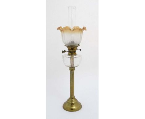 Oil lamp : a c 1900 brass and glass oil lamp with circular reeded column, circular base , clear glass reservoir , twin burner
