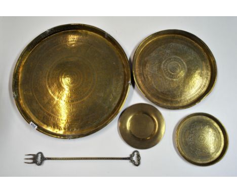 A four eastern brass trays and a toasting fork.