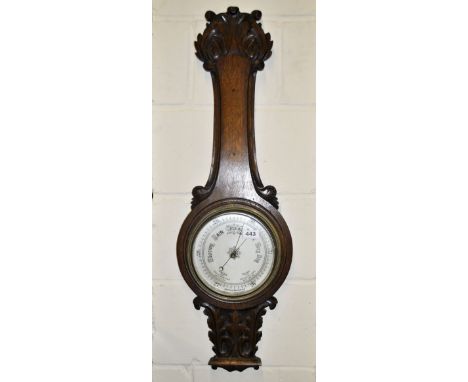 A large carved oak barometer, H. 90cm.