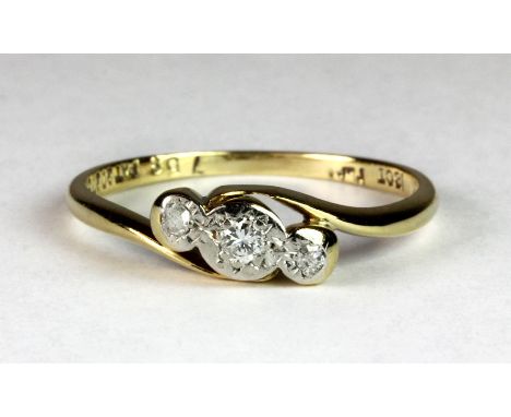 An 18ct gold and platinum ring set with three diamonds (O).