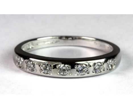 A 9ct white gold diamond set half eternity ring, (M).