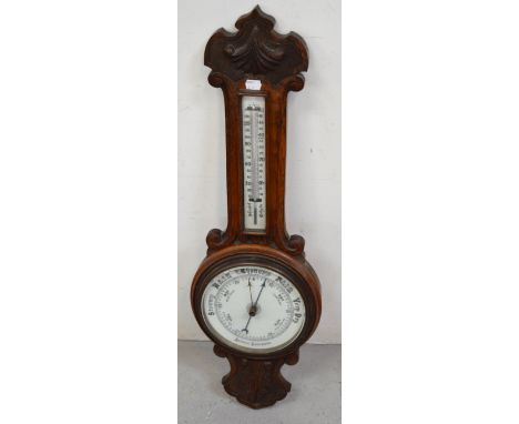 A carved oak aneroid wall barometer, height 84cm.