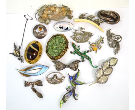 A collection of silver and metal brooches to include a silver and enamelled lizard, a donkey, a sailing ship, an enamelled an