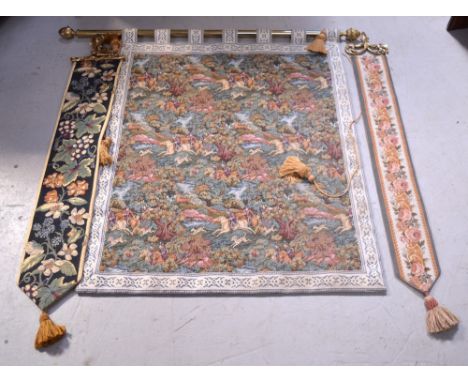 A tapestry wall hanging decorated with a hunting scene, presented on brass pole, height 103cm and two further slim decorative