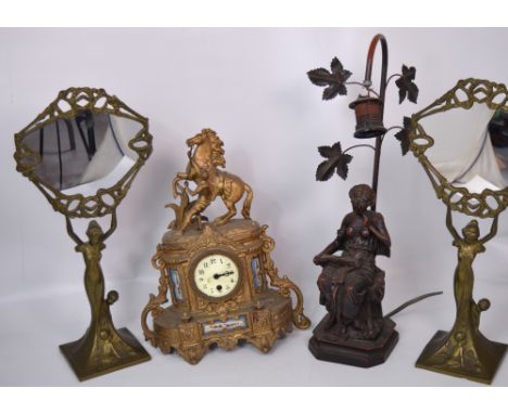 A gilt heightened spelter clock (af), a pair of Art Nouveau style brass table mirrors and a bronzed resin table lamp (4).