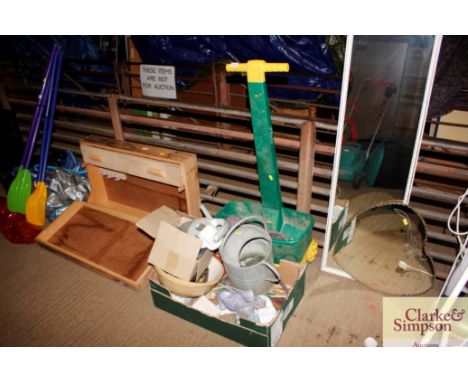 A seed spreader; a decoy bird; a box containing various hand tools; a galvanised watering can etc.