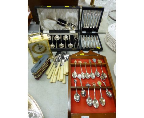 Cased cutlery set, commemorative diecast tram, carriage clock, souvenir spoons on a rack etc