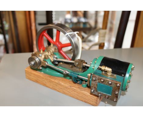 A Stuart live steam stationary engine (No.8). Single cylinder horizontal engine with 90mm flywheel. Mounted on wooden base an
