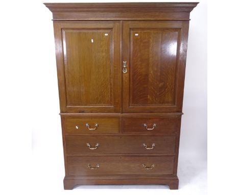 An early 20th century 2-section oak linen press, by Maple & Co of London, having 3 slides and 4 drawers, on bracket feet, W13