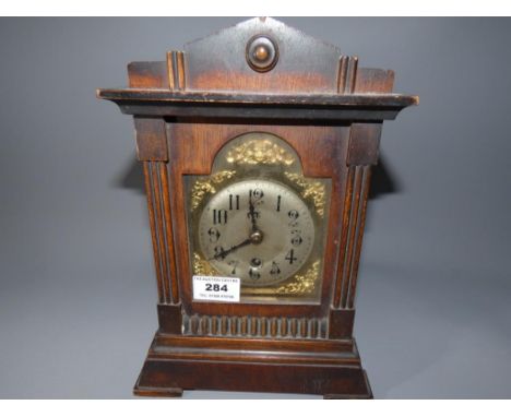 An oak cased timepiece mantel clock by HAC, brass arched dial with applied silvered chapter ring and spandrels, with pendulum