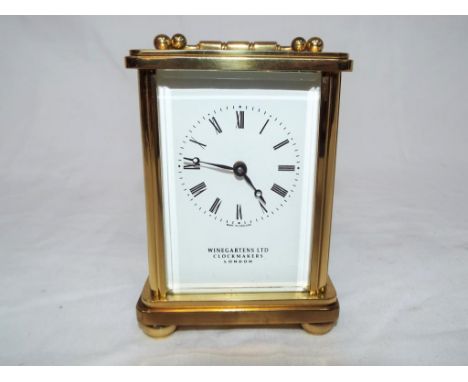 An early 20th century brass cased timepiece only mechanical carriage clock, white enamel dial with Roman numerals marked Wine