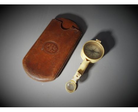 A German compass in bakelite case and magnifying glass attachment and a leather cigar case