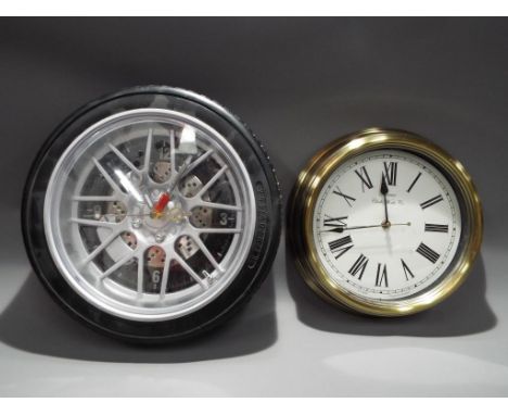 Two modern wall clocks, one in the form of a car tyre.