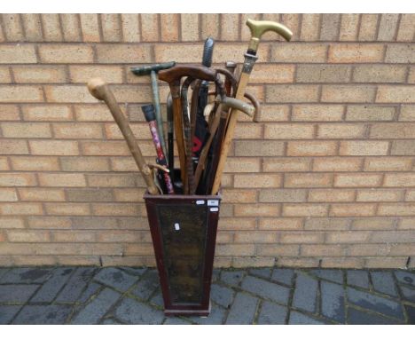 A walking stick holder with a quantity of walking sticks and similar, including silver mount examples.