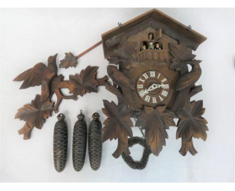 A wall mounted cuckoo clock with 3-train musical movement and automaton carousel with figures, together with 3 cast pine cone