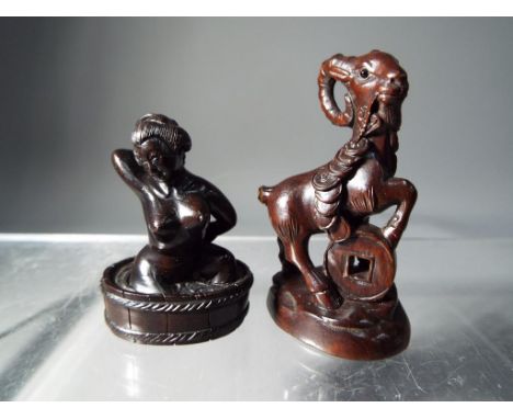 Netsuke - two vintage dark wood Japanese netsukes one in a form of a mountain goat type animal, the other depicting a bathing