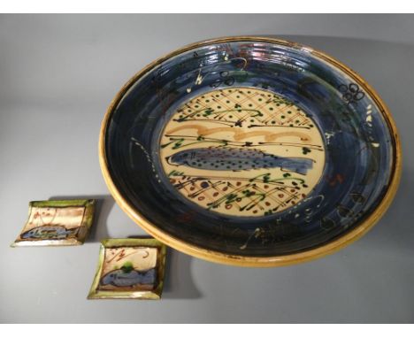 A large studio pottery shallow bowl decorated with fish, signed to the base Niel and two similar ceramic stands [3].Condition