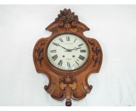 A French vineyard wall clock with pendulum, case carved with foliage and scrollwork surmounted by a carved floral decoration,