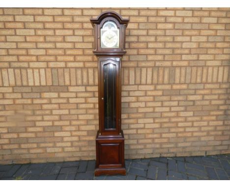 A contemporary grandmother style clock in a dark wood case, arched brass dial, glazed panel to opening trunk door, Westminste