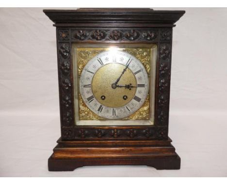 A carved oak mantel clock by Lenzkirch, the hour and half gong striking movement having the Lenzkirch stamp, square brass dia