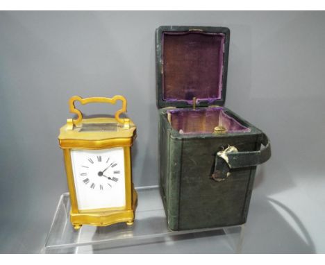 A French gilded serpentine cased carriage clock, timepiece movement with platform lever escapement, white enamel dial, in ori