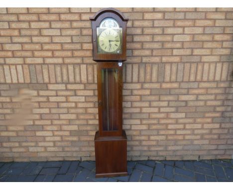 A contemporary grandmother style clock in a dark wood case, arched brass dial, glazed panel to opening trunk door, Westminste