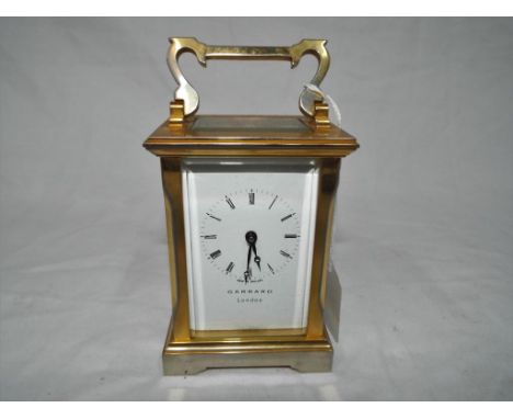 A good brass cased timepiece only mechanical carriage clock, white enamel dial with Roman numerals signed Garrard.