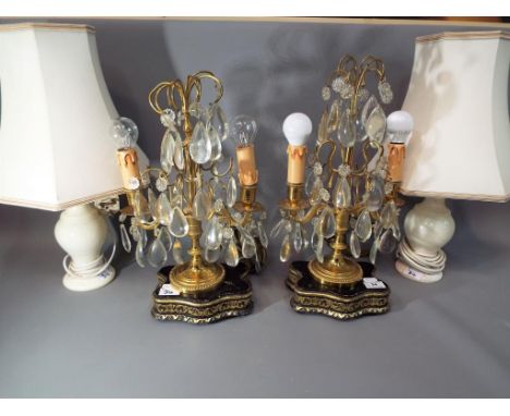 Two lustre table lamps on wooden plinths with gilded highlights and a further matched pair of hardstone table lamps with shad