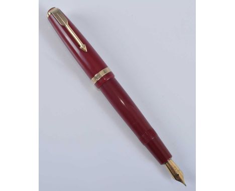 A Parker Duofold fountain pen, in deep red with gold trim, the barrel faintly engraved PARKER DUOFOLD  MADE IN ENGLAND, the n