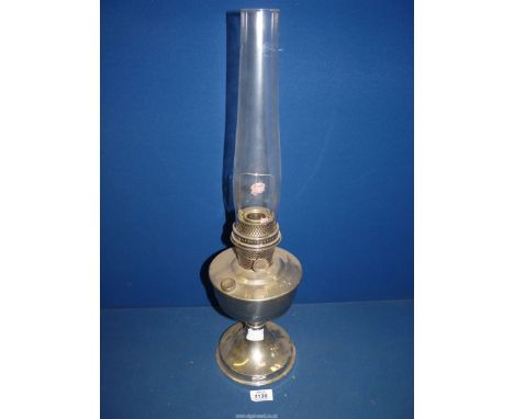 A metal based Oil lamp with glass chimney, single burner, 23'' high overall.
