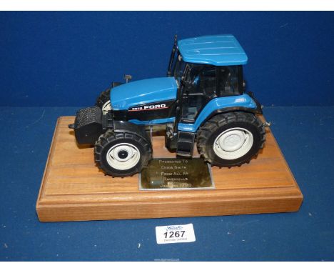 A model Ford 8970 tractor on plinth with presentation plaque.