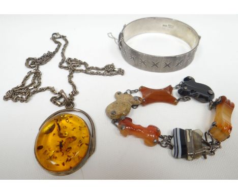 A bright-cut silver bangle, an agate and silver bracelet and an oval amber pendant