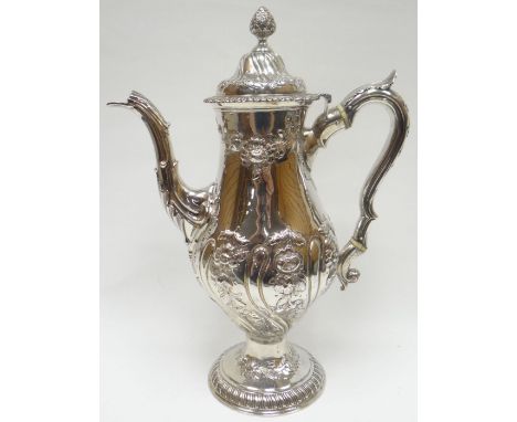 A good Irish George III silver coffee-pot, raised on a circular foot and highly decorated with floral embossing, with scrolle