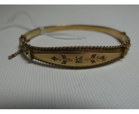 A 9ct yellow gold clasp-bangle with central rope-twist bordered fascia set with single diamond, 7.43gms
