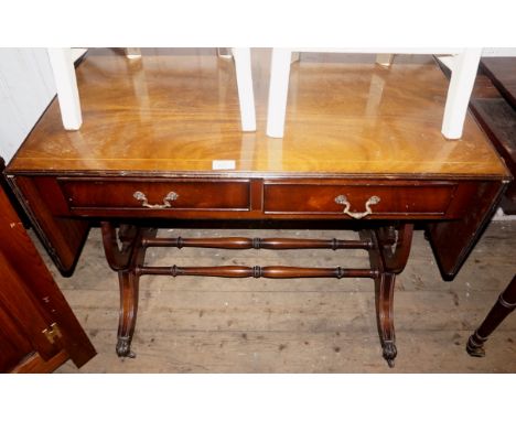 A reproduction mahogany drop leaf sofa table raised on lyre supports.