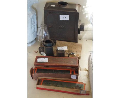 A Victorian projector with a quantity of various glass slides including nursery rhyme examples.