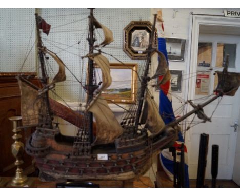 A vintage wooden model of a three masted ship.