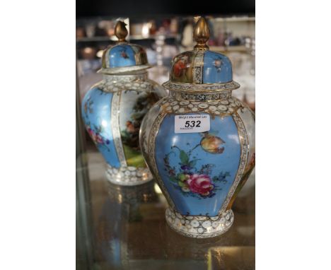 A pair of Czechoslovakian ceramic continental jars and covers depicting in ladies in an outdoor garden landscape.