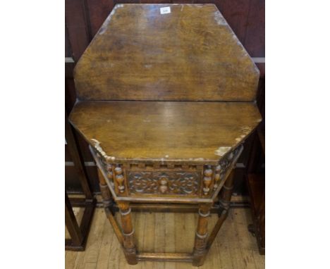 A reproduction oak Jacobean revival fold over table