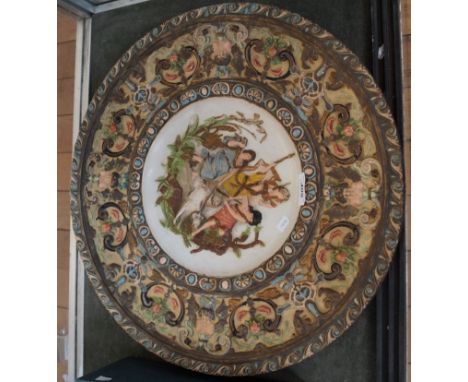An early 20th Century continental ceramic charger relief decorated with warriors and a dog, impressed marks to base.