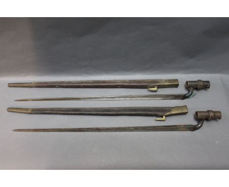 Two Victorian military bayonets, 21 1/2" triangular hollow ground blades, in leather scabbards with brass fittings, one scabb