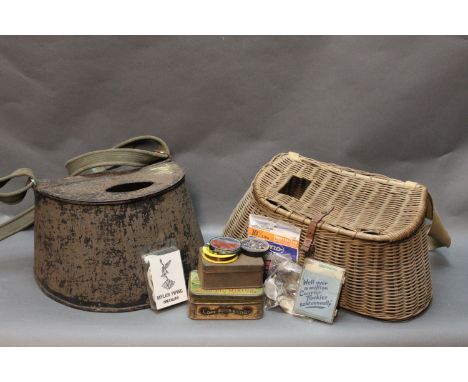 Two creels, the first wicker and containing various pieces of vintage tackle, height 18 cm, and a metal creel, height 17 cm.