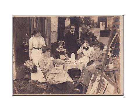 Featuring group of actors including Edwin Carewe (1883-1940) gathered near easel &amp; paintbrushes.Setting appears to be art
