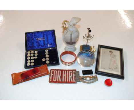 A box containing a part cased set of enamel buttons, an enamel 'For Hire' sign, a glass paperweight, etc.